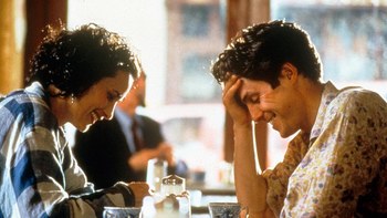 Andie McDowell e Hugh Grant parlano e ridono seduti al tavolo di un bar londinese in Quattro Matrimoni e un Funerale. Chiara Veccia per CanadaUsa