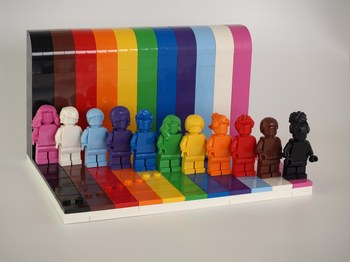 Personaggi Lego di diversi colori sulla bandiera arcobaleno