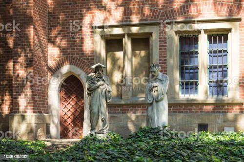Krakow, Poland, Aug 17 2018: Garden of The Jagiellonian University Museum. Two statues of scientists near old university building