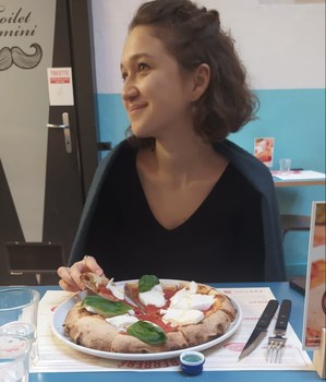 Maria eating a delicious pizza