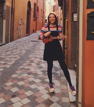 Charline playing the ukulele in a street in Cesena