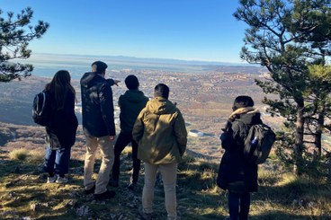 Researchers stand on the escarpment looking out over the city of Trieste