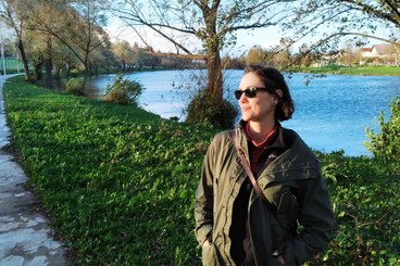 Research Fellow Yolanda Weima standing beside the blue Una river on a sunny day in Bihać